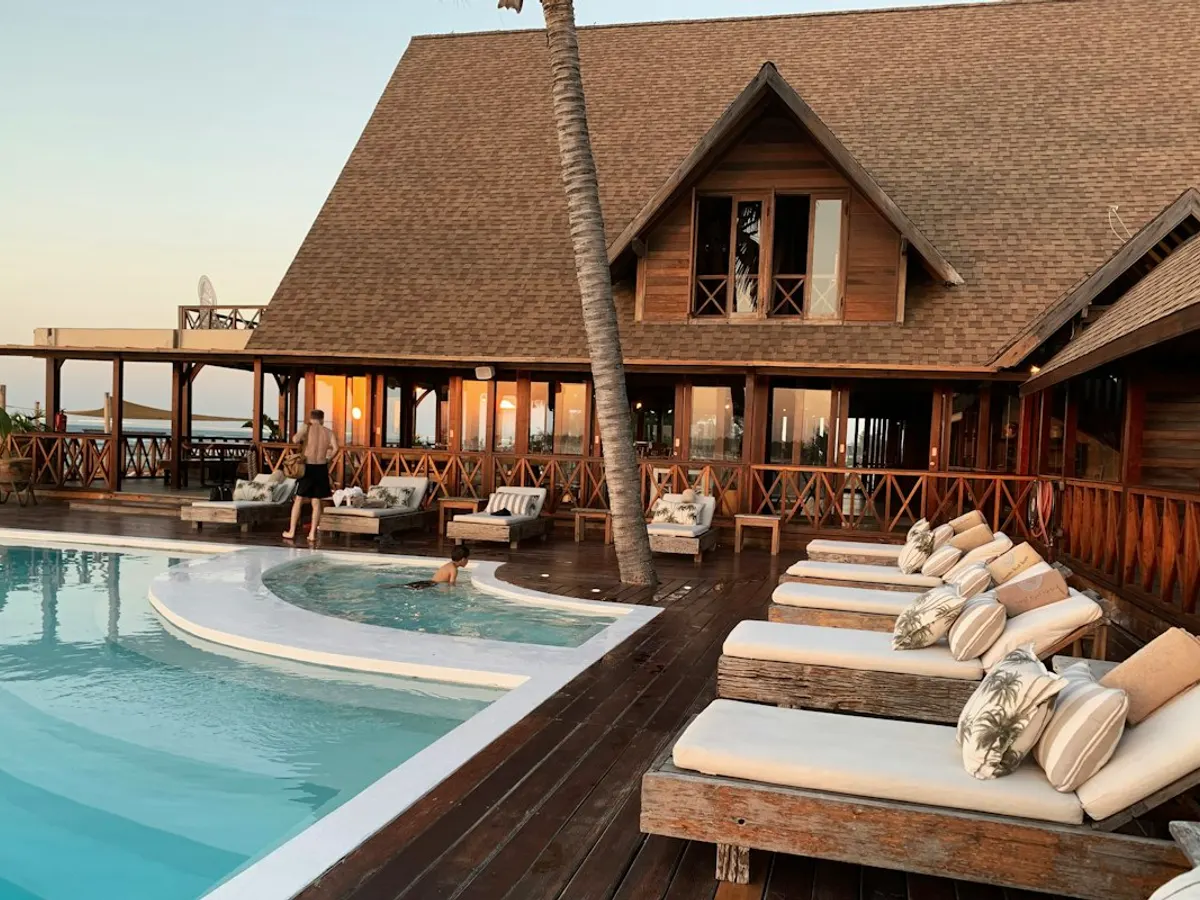 Poolside hotel terrace with timber architecture and warm evening light
